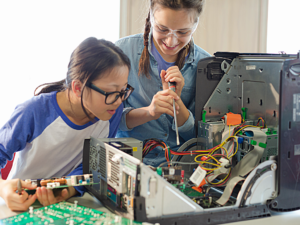 2 Girls working together to building a computer tower.